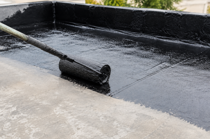 Application d'une couche d'étanchéité au rouleau sur une terrasse avant la pose du carrelage